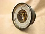 19th century aneroid barometer with curved thermometer.